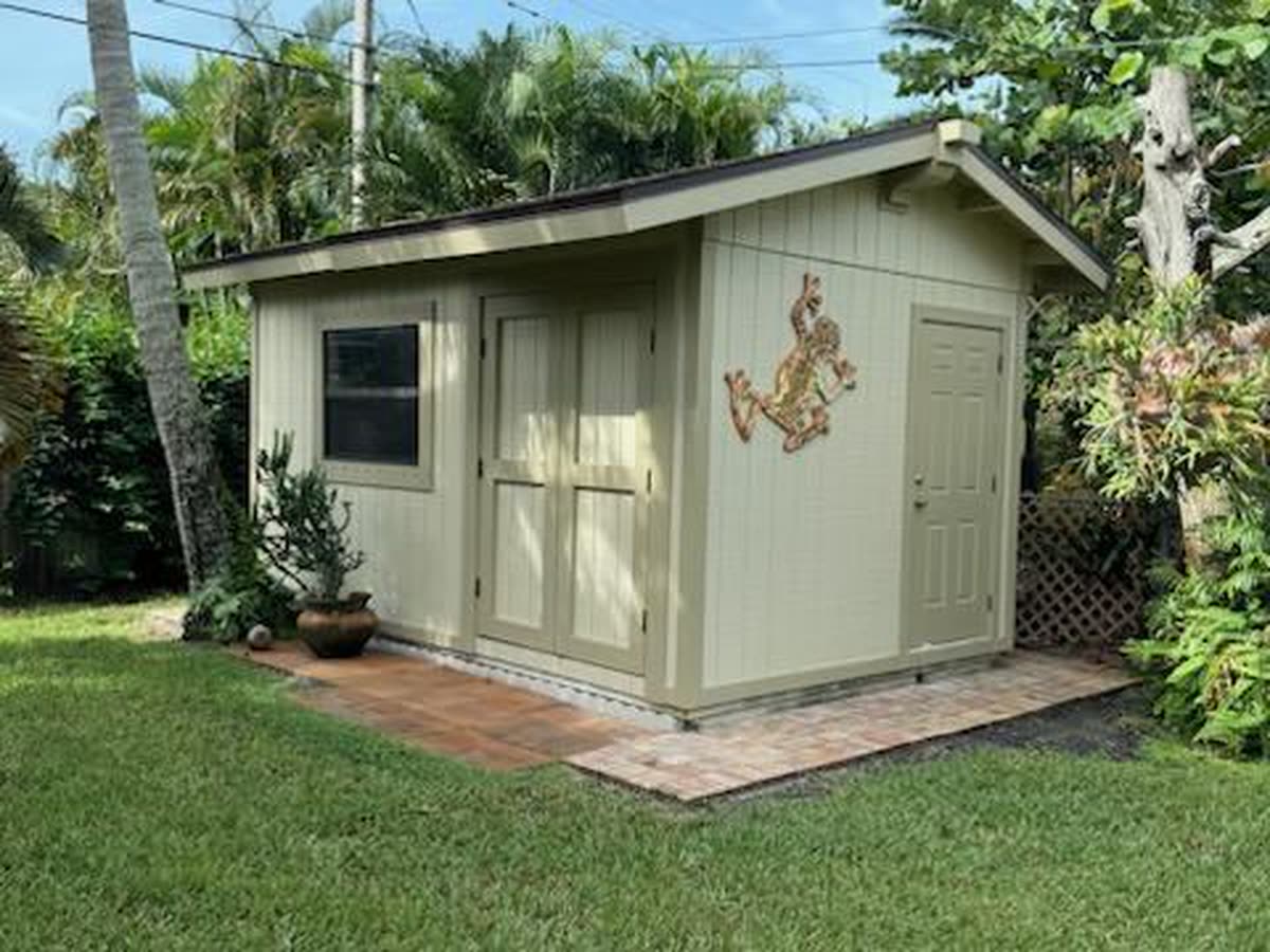 A paver pad in front of a garden shed.
